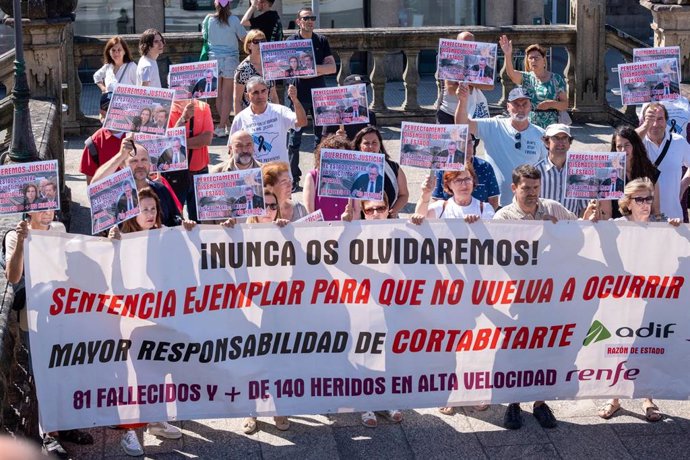 Varias personas con una pancarta y carteles durante una concentración de las víctimas de Angrois, en la estación de tren de Santiago, a 24 de julio de 2024, en Santiago de Compostela, A Coruña, Galicia (España). Víctimas del accidente del tren Alvia en An