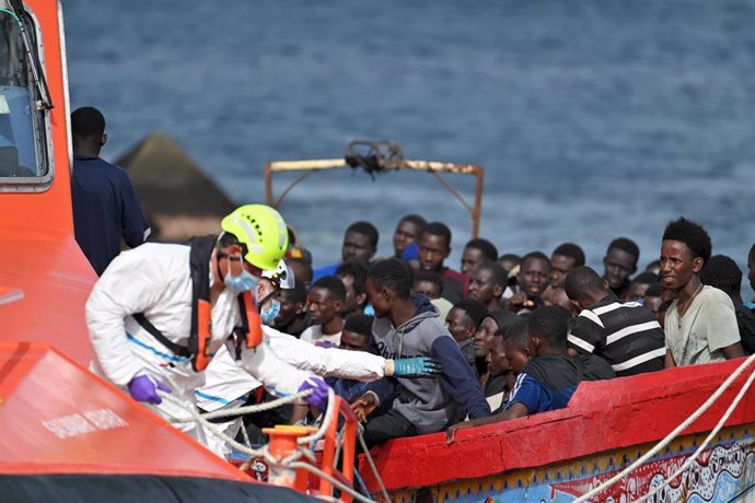 Trabajadores ayudan a los 116 migrantes que llegan en patera al puerto de La Restinga, trasladados por Salvamento Marítimo, a 26 de julio de 2024, en El Hierro, Santa Cruz de Tenerife, Canarias (España). El barco de Salvamento Marítimo, Salvamar Adhara, h