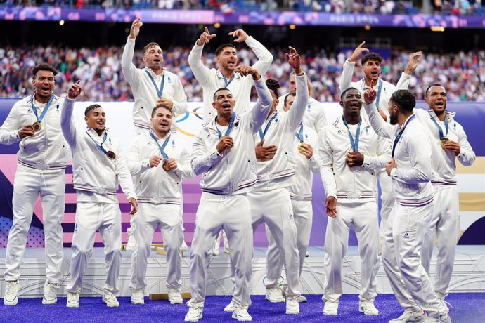 27 July 2024, France, Paris: France players celebrate winning gold after the rugby sevens gold medal match between France and Fiji at the Stade de France on the first day of the 2024 Paris Olympic Games. Photo: Mike Egerton/PA Wire/dpa