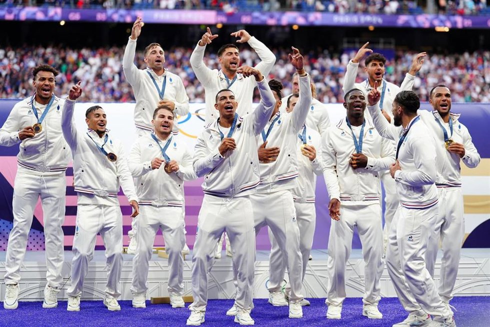 27 July 2024, France, Paris: France players celebrate winning gold after the rugby sevens gold medal match between France and Fiji at the Stade de France on the first day of the 2024 Paris Olympic Games. Photo: Mike Egerton/PA Wire/dpa