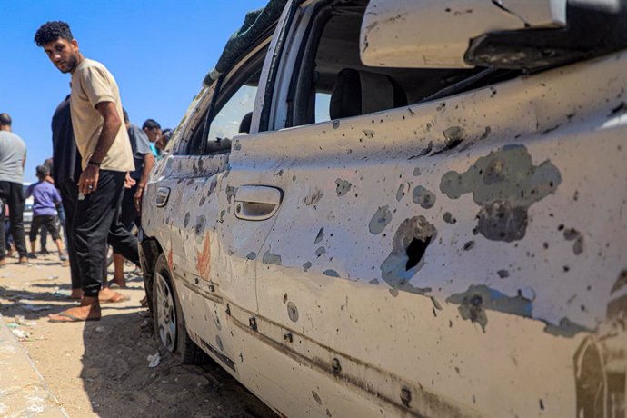 AL-MAWASI, July 16, 2024  -- Palestinian people inspect a damaged car following an Israeli attack in the al-Mawasi area in the southern Gaza Strip city of Khan Younis, on July 16, 2024. The Israeli army committed a "terrible massacre" against the displace