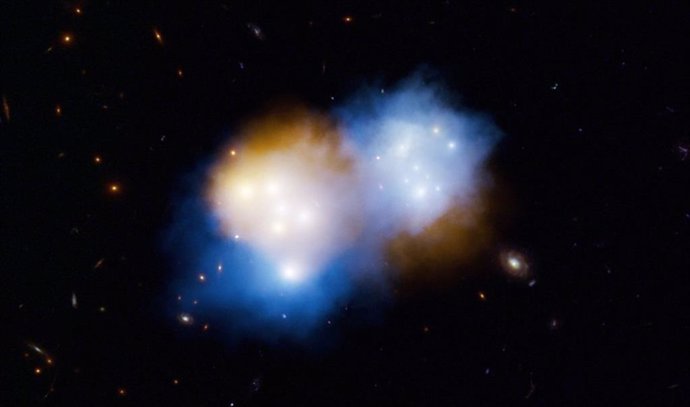 Esta concepción artística muestra lo que ocurrió cuando dos cúmulos masivos de galaxias, conocidos colectivamente como MACS J0018.5, colisionaron