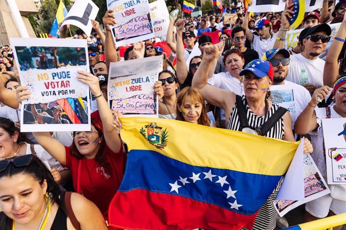 Manifestantes con pancartas durante una protesta en apoyo a la oposición venezolana