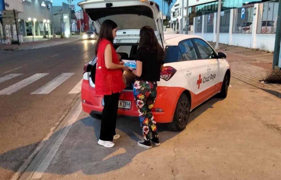 Una voluntaria de Cruz Roja presta atención a una mujer.