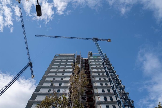 Archivo - Varias grúas en una zona de edificios de viviendas