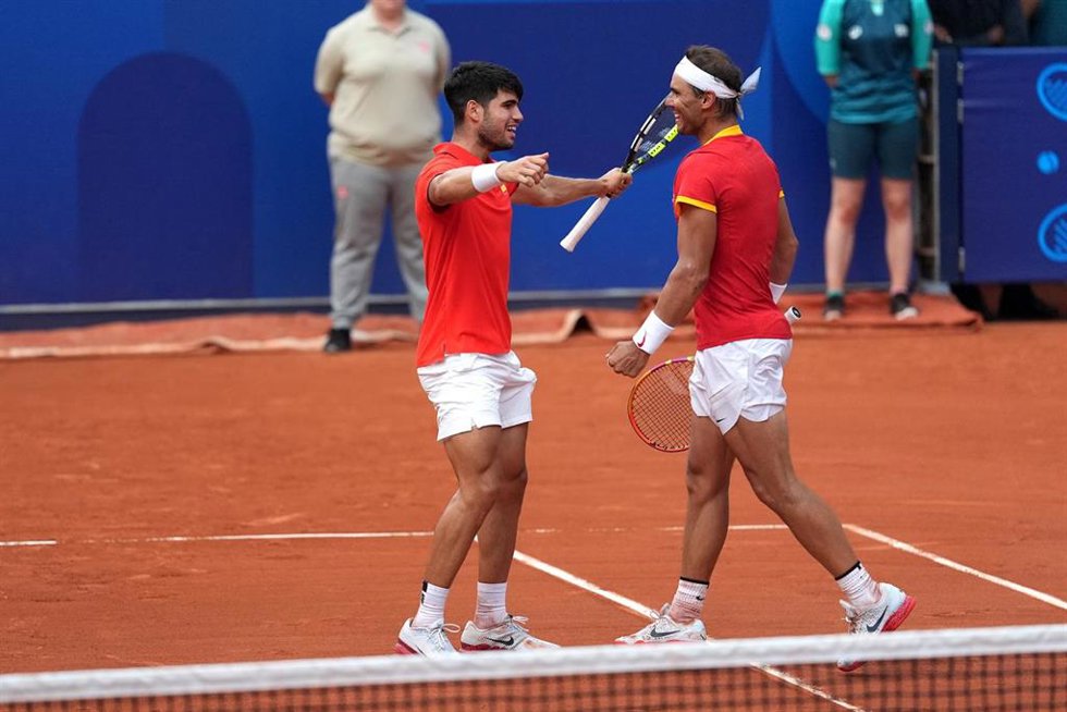 30 July 2024, France, Paris: Spainsh teannis players Carlos Alcaraz and Rafael Nadal (R) celebrate victory over Netherlands' Tallon Griekspoor and Wesley Koolhof (not pictured) during the men's doubles second-round match at Roland-Garros on the fourth d
