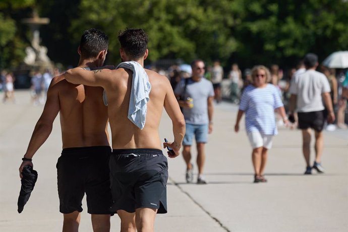 Dos homes sense samarreta al parc del Retiro de Madrid.