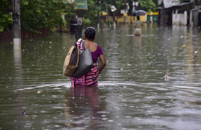 Archivo - Mujer en una calle inundada en India.
