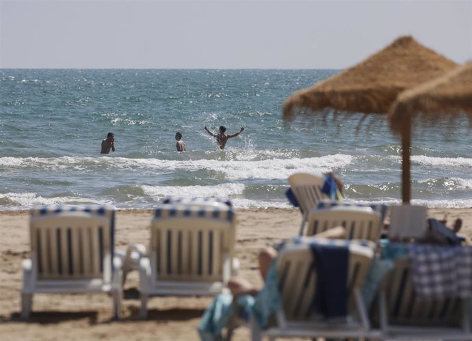 Archivo - Varias personas se bañan en la playa de la Malvarrosa