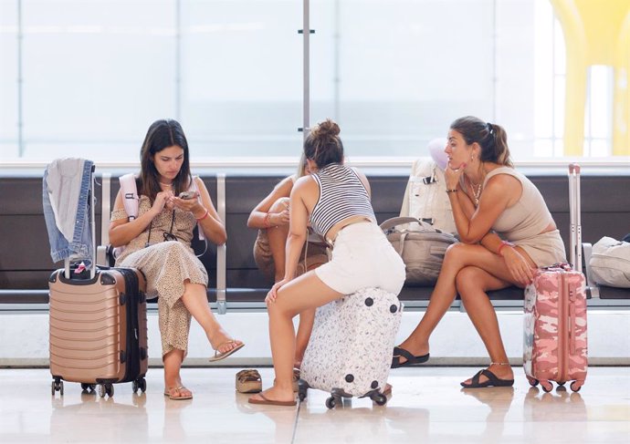 Archivo - Un grupo de jóvenes conversan sentadas en algunos de los asientos de la Terminal T4 del Aeropuerto Adolfo Suárez-Madrid Barajas, a 28 de julio de 2023, en Madrid (España).