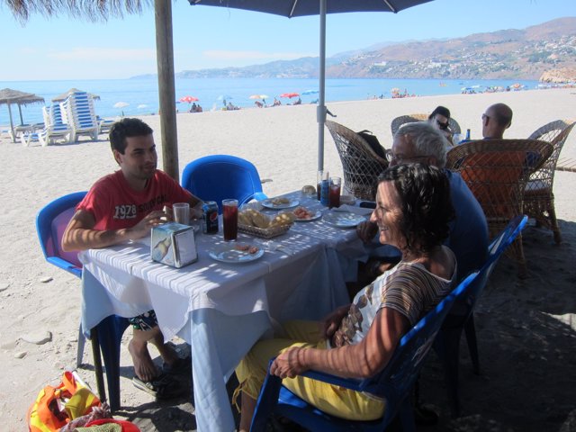 Personas comiendo en la playa