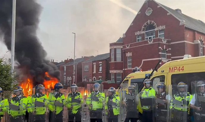 Furgón policial en llamas en la localidad británica de Southport en medio de protestas violentas por la muerte de tres menores víctimas de un apuñalamiento múltiple