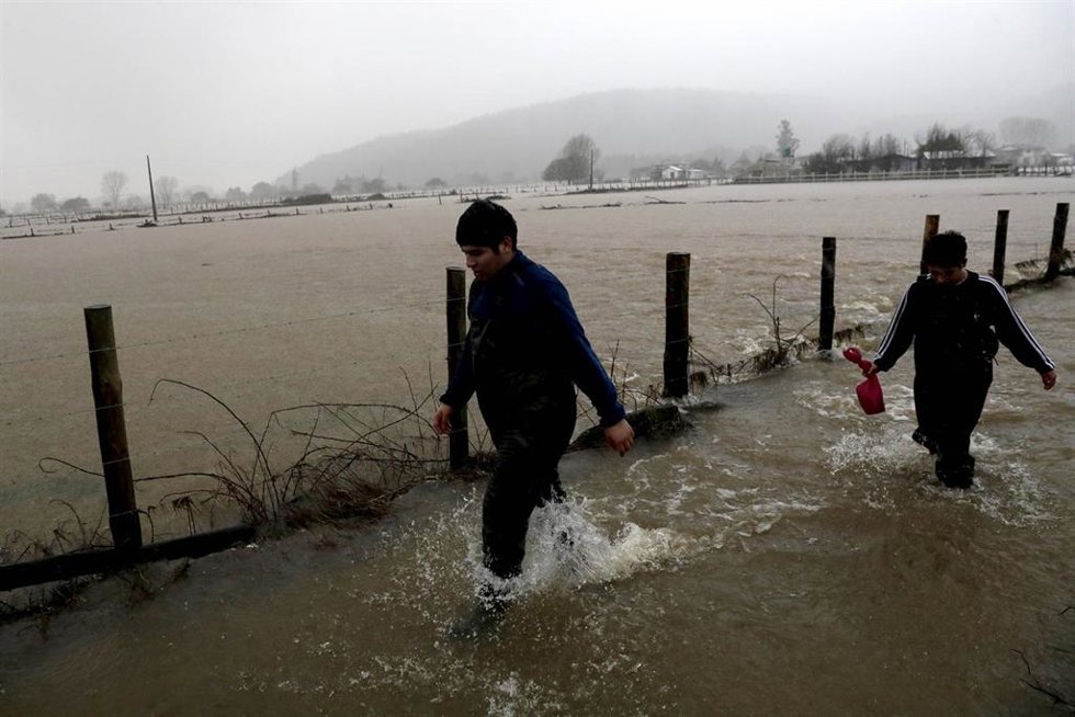 Archivo - ARAUCO, June 15, 2024  -- People wade through flood water in Arauco, Biobio region, Chile, June 13, 2024. Chile on Thursday declared a swath of the country, including the capital, a disaster zone after a storm left one person dead and displace