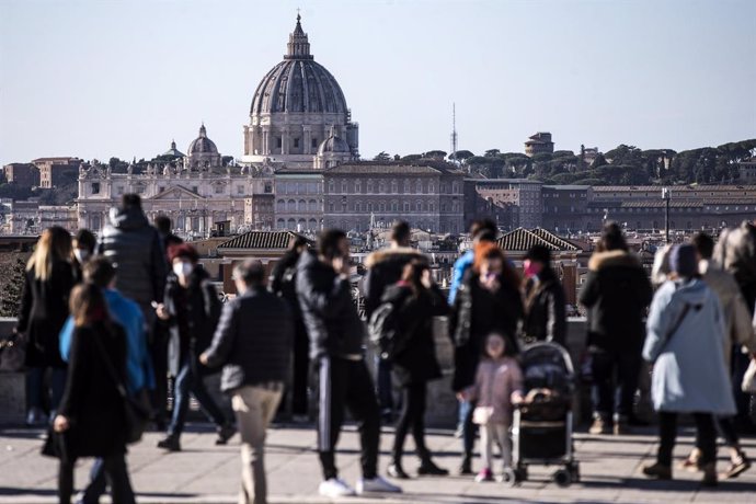 Archivo - Personas con mascarilla con el Vaticano de Roma al fondo