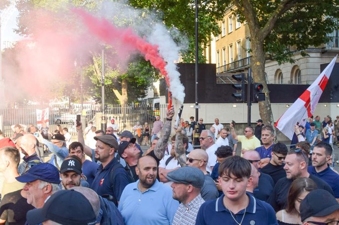 July 31, 2024, London, England, UK: Protesters set off smoke flares outside Downing Street. Crowds attacked police officers and threw projectiles in Westminster as protesters turned violent after three young girls were killed in a knife attack in Southp