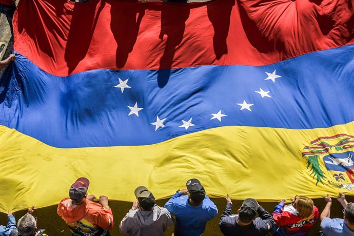 Simpatizantes del presidente de Venezuela, Nicolás Maduro, portan una bandera durante una manifestación en apoyo a los resultados electorales