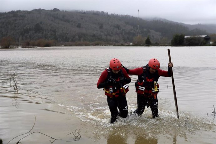 Archivo - ARAUCO, June 15, 2024  -- Members of a rescue team wade through the overflowing Pichilo River in Arauco, Biobio region, Chile, June 13, 2024. Chile on Thursday declared a swath of the country, including the capital, a disaster zone after a storm