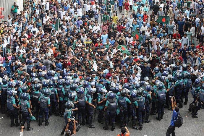 Estudiantes y aspirantes a un puesto de trabajo portando banderas nacionales participan en una marcha de protesta en Dhaka, Bangladesh