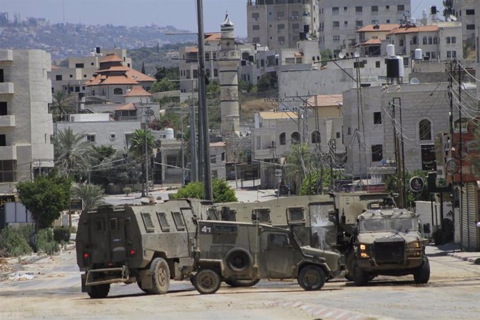 Vehículos militares israelíes patrullan la calle durante una incursión de las fuerzas israelíes en un campo de refugiados en Tulkarem (Cisjordania)