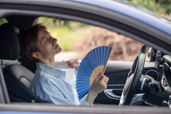 Archivo - Mujer dentro de un coche abanicándose por el calor.