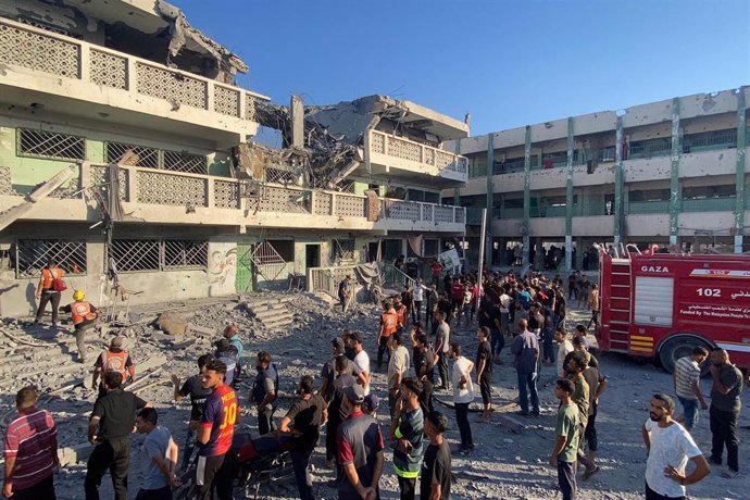 Palestinos inspeccionan el lugar de los ataques israelíes contra una escuela que acoge a desplazados, en Sheij Radwan, Ciudad de Gaza