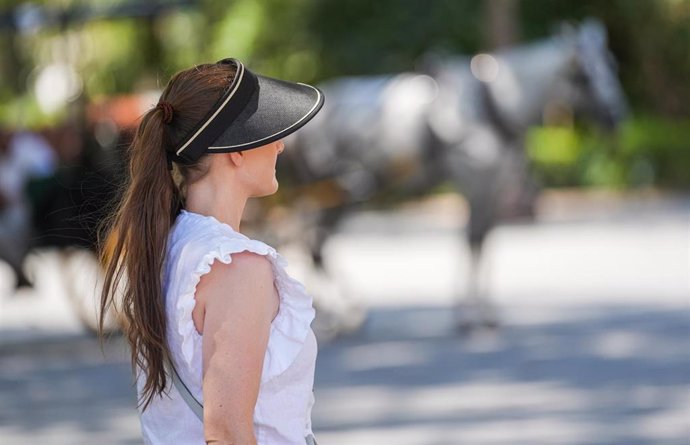 Una mujer con visera y manga corta. A 05 de julio de 2024, en Sevilla (Andalucía, España). Andalucía afronta este martes la primera jornada de la segunda ola que se extenderá hasta el jueves 25 de julio, tras la finalización de la primera ola de calor del