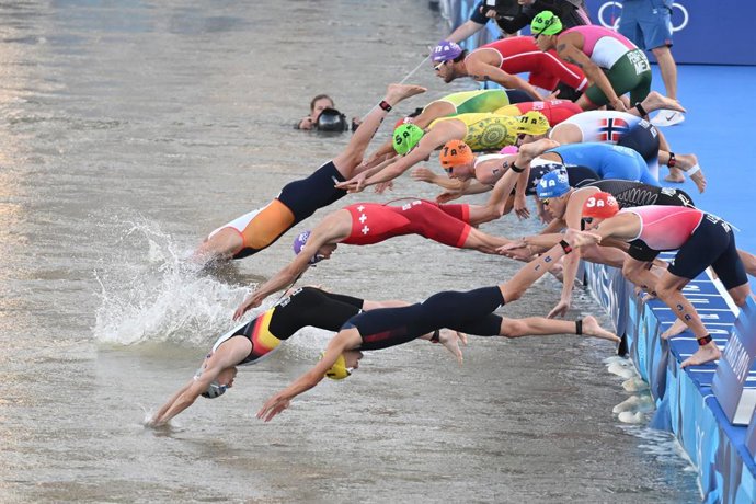 05 August 2024, France, Paris: Germany's Tim Hellwig (C) and the competitors jump into the water of the Seine to start the swimming leg during the Mixed Triathlon at Pont Alexandre III. Photo: Marijan Murat/dpa