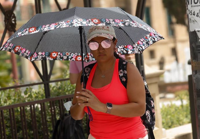 Archivo - Una mujer se protege del sol con un paraguas durante un día de alerta roja por altas temperaturas, a 12 de julio de 2021, en la ciudad de Murcia, Murcia (España). 