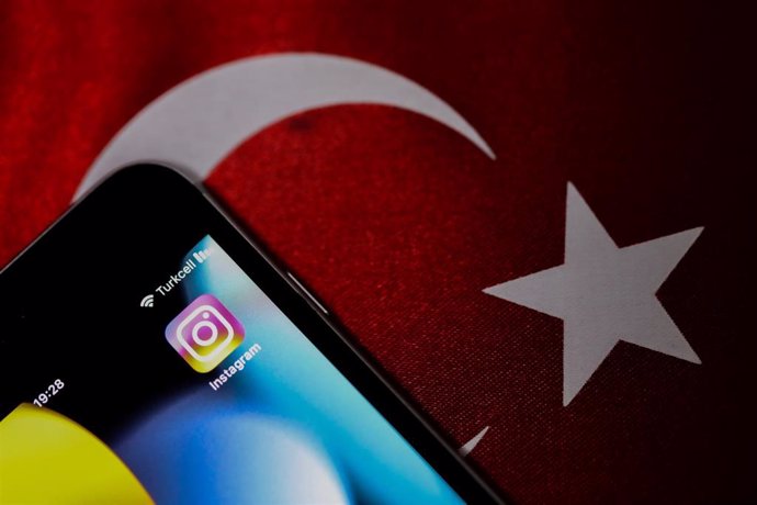 Imagen de archivo de un teléfono móvil con la aplicación Instagram frente a una bandera de Turquía