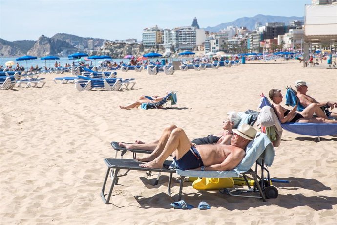 Archivo - Numerosas personas toman el sol en la playa de Poniente, en Benidorm, Alicante.