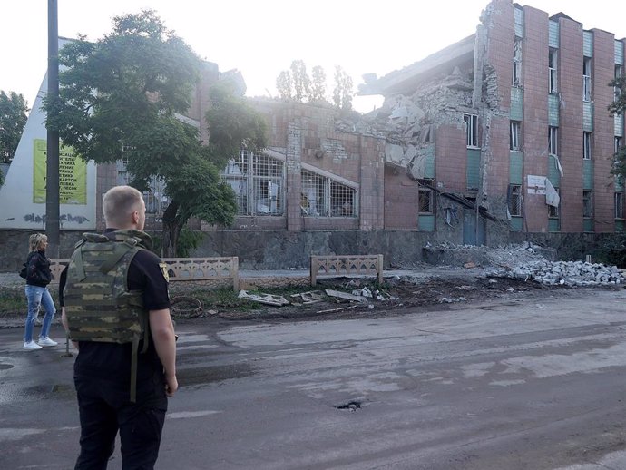 Archivo - May 31, 2024, Kharkiv, Ukraine: KHARKIV, UKRAINE - MAY 31, 2024 - A law enforcer in a bulletproof vest faces a building damaged by the overnight Russian missile attack in the Novobavarskyi district of Kharkiv, northeastern Ukraine. Five people h