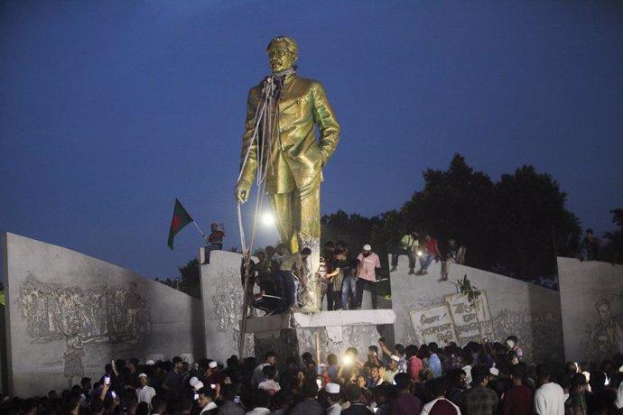 August 5, 2024, Dhaka, Dhaka, Bangladesh: Anti-government protestors climbs atop a statue of Sheikh Mujibur Rahman, Bangladesh's founding father and parent of the country's ousted Prime Minister Sheikh Hasina, in Dhaka on August 5, 2024. Bangladeshi Prime