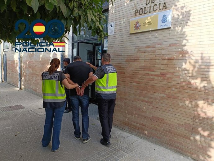 Agentes de la Policía Nacional con uno de los detenidos.