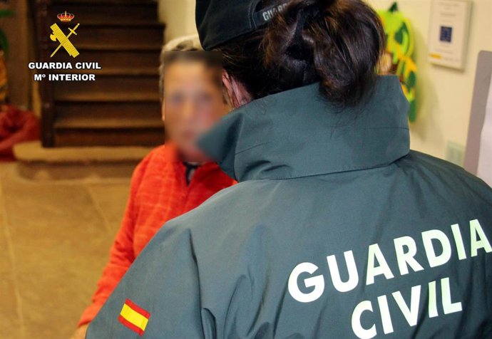 Fotografía de archivo de una guardia civil con una mujer en una zona rural de Cantabria