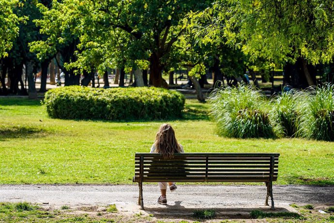 Archivo - Una mujer toma el sol en un banco del Parque de Los Príncipes.