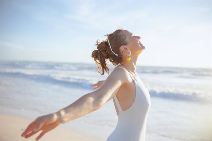 Archivo - Mujer en la playa recibiendo vitamina D del sol