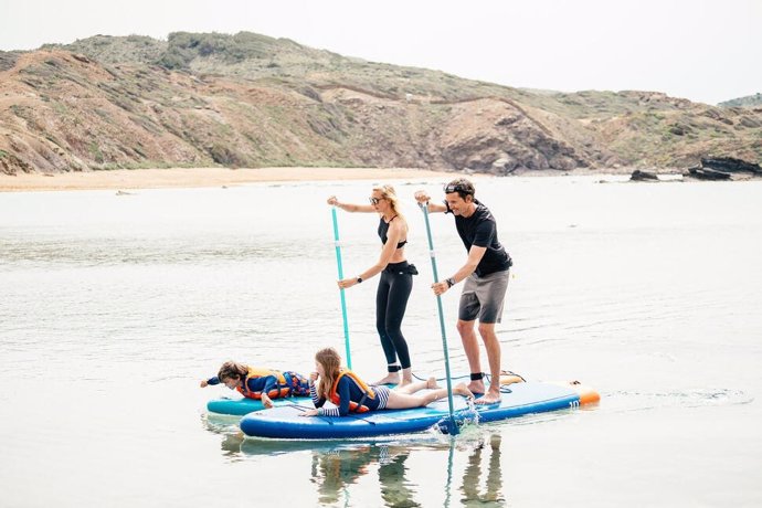 Imagen de una familia con la tabla hinchable de paddle surf de Decathlon