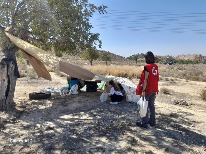 Voluntarios de Cruz Roja en Alicante entregan kits contra el calor a personas sin hogar.