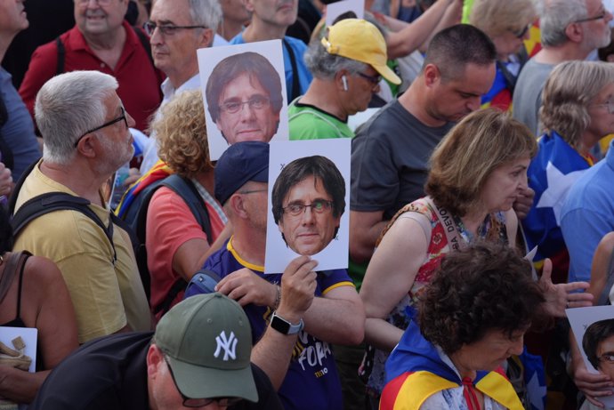 Varias personas con fotos con la cara de Puigdemont durante una concentración para recibir al expresidente de la Generalitat Carles Puigdemont en el paseo Lluís Companys, a 8 de agosto de 2024, en Barcelona, Catalunya (España).