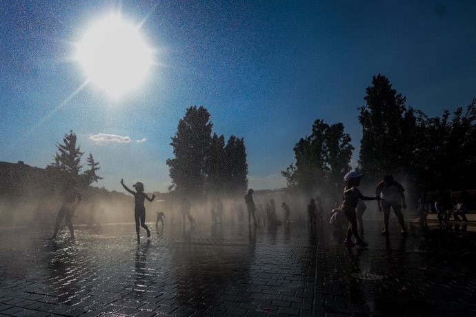 Varios niños se refrescan en una fuente durante la tercera ola de calor en Madrid, en el parque Madrid Río 