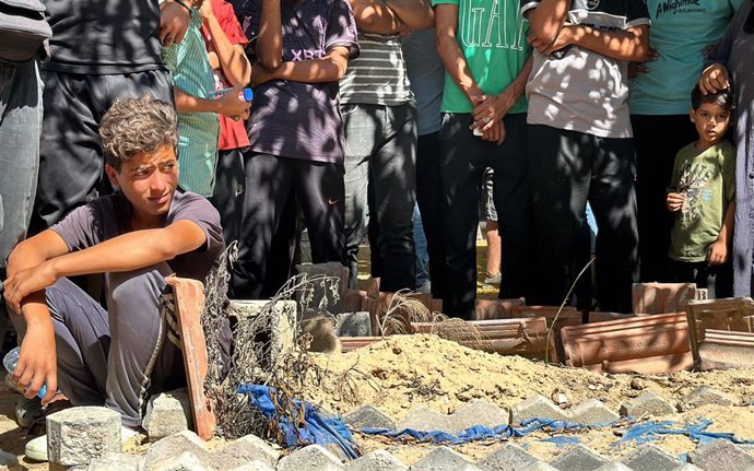 July 18, 2024, Khan Yunis, Gaza Strip, Palestinian Territory: Palestinians gather a the site before the Palestinian Civil Defense exhumes 12 bodies from what they are calling a mass grave inside the Al-Amal Hospital of the Red Crescent Society in Khan Yun