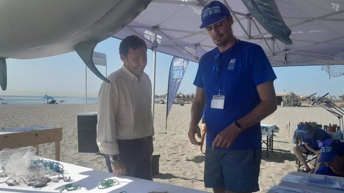 El subdelegado de la Junta de Andalucía en el Campo de Gibraltar, Javier Ros, junto a uno de los monitores de la campaña 'Andalucía, Mares que Saben' en la playa de San Roque.