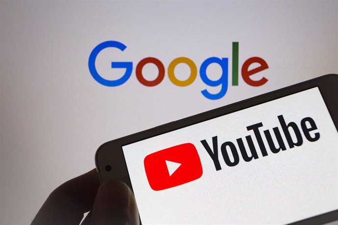 Archivo - 04 September 2019, Paraguay, Asuncion: A person holds smartphone with YouTube logo, an American video sharing website, on a screen and in the background Google's logo, an American multinational technology company.