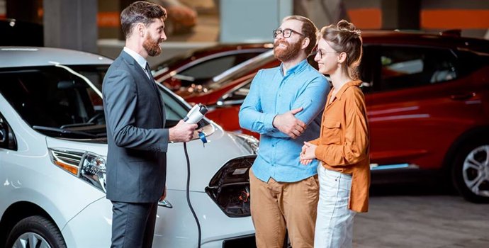 Clientes preguntando por un coche eléctrico en el concesionario