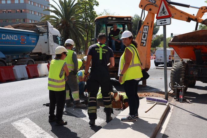 Un bombero y trabajadores de la obra supervisan la zona de la Avenida de las Ciencias en Sevilla este, donde se ha producido un escape de gas. A 09 de agosto de 2024, en Sevilla (Andalucía, España).