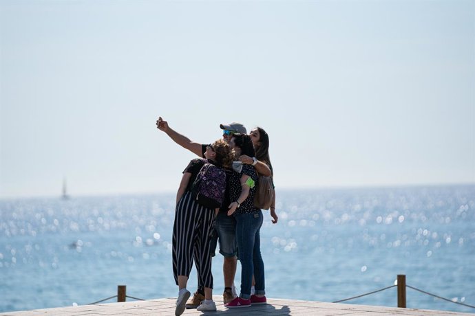 Archivo - Un grupo de personas se hace un selfie en la playa