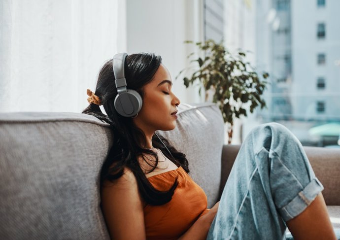 Archivo - Mujer con cascos escuchando música.