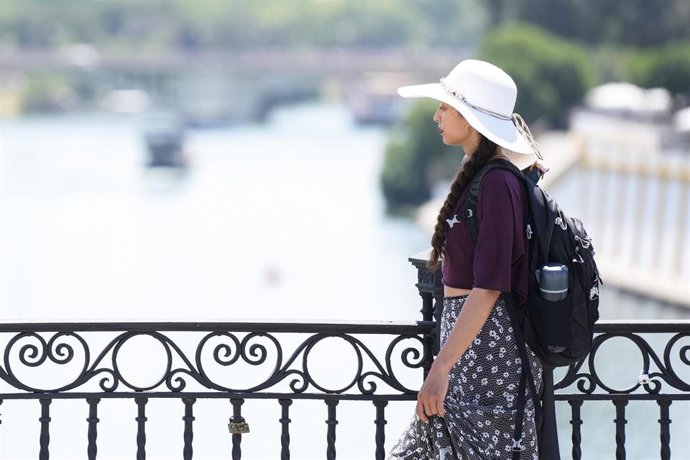 Archivo - Una joven porta un sombrero para protegerse del calor en Sevilla en una imagen de archivo.
