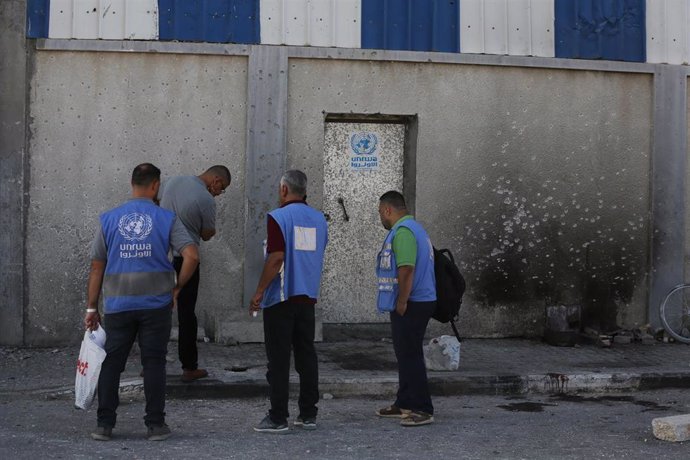 Archivo - Personal de la UNRWA frente a un almacén de la Agencia destruido por el Ejército de Israel en Al Maghazi, Franja de Gaza  