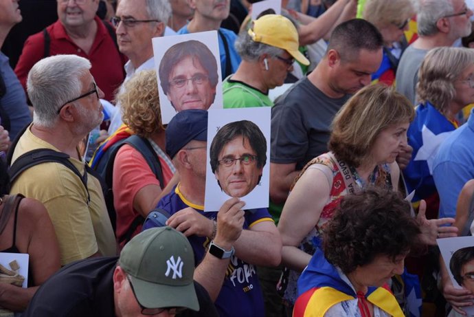 Archivo - Varias personas con fotos con la cara de Puigdemont durante una concentración para recibir al expresidente de la Generalitat Carles Puigdemont en el paseo Lluís Companys de Barcelona